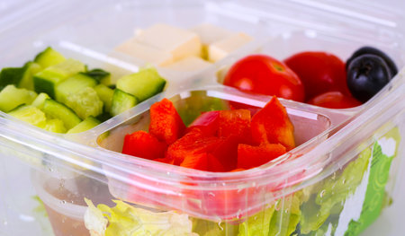 chopped vegetables for Greek salad in a plastic bowl