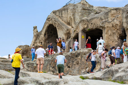 Crowds of tourists explore caves and ruins in Uplistsikhe, Georgiaのeditorial素材