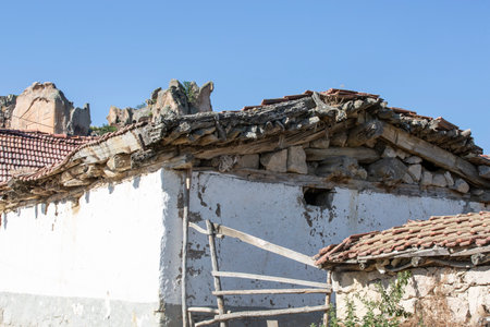 Old broken roof of a village house with white wallsの写真素材