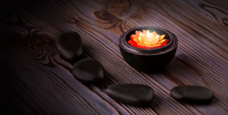 black stones and a candle on wooden backgroundの写真素材