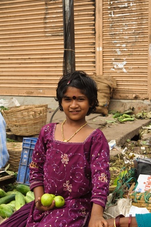 BANGALORE, IN - JUNE 26: Vendor girl sells fruit on an unnamed street in Bangalore, IN June 26, 2011 in Bangalore, India. 42% of India falls below the international poverty line of $1.25 a day.のeditorial素材
