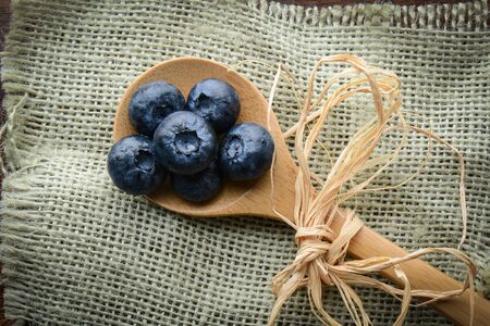 Blueberries on a Spoon with Burlap Woven Backgroundの写真素材