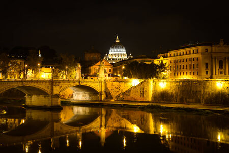 ROME, ITALY -OCTOBER 18, 2014: Monumental St. Peters Basilica over Tiber at night in Rome, Italy. St. Peters Basilica is papal late renaissance basilica consecrated in 1626.のeditorial素材