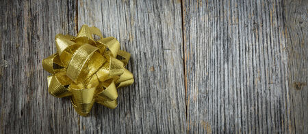 Gold Holiday Bow on Rustic Wood Backgroundの写真素材