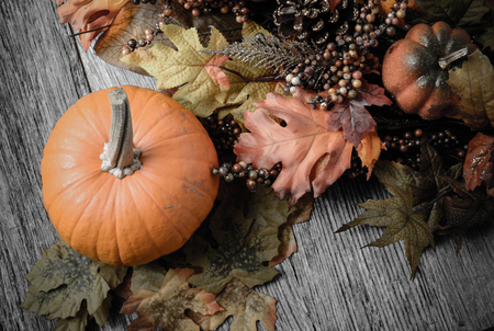 Pumpkin and Fall Leaves on Rustic Wood Backgroundの写真素材