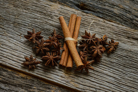 Cinnamon sticks and star anise on rustic wood backgroundの写真素材