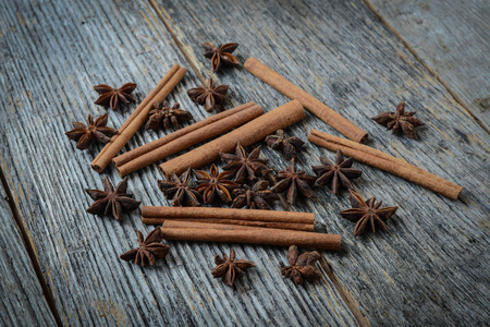 Cinnamon sticks and star anise on rustic wood backgroundの写真素材