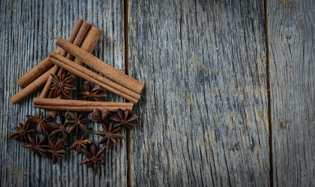 Cinnamon sticks and star anise on rustic wood backgroundの写真素材