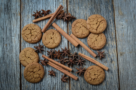 Cinnamon sticks, star anise and gingersnap cookies on rustic wood backgroundの写真素材