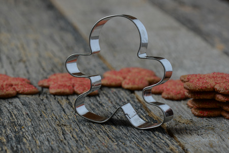 Gingerbread Cookie and Cutter on Wood Background