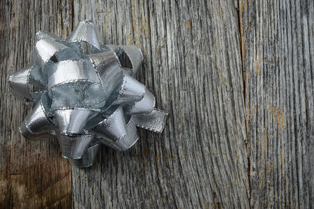 Silver Holiday Bow on Rustic Wood Backgroundの写真素材