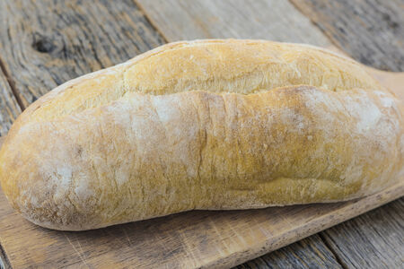 Bread on a Bread Board with Rustic Wood Backgroundの写真素材