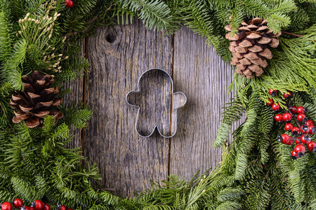 Christmas Wreath with Gingerman Cookie in the Middle of Wood Backgroundの写真素材