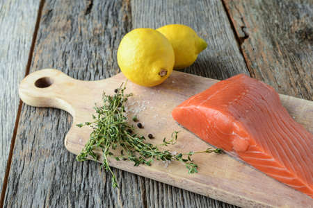 Salmon on a Cutting Board with Lemon, Salt and Pepperの写真素材
