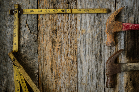 Hammers and Measuring Tape on Rustic Old Wood Backgroundの写真素材