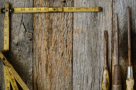 Measuring Tape and Screwdriver on Rustic Old Wood Backgroundの写真素材