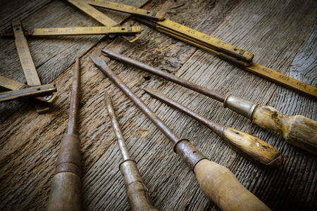 Old Tape Measure and Screwdriver for Construction on Rustic Wood Backgroundの写真素材
