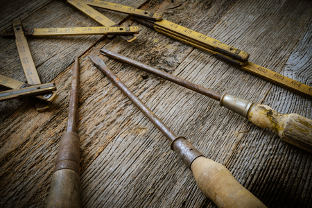 Old Tape Measure and Screwdriver for Construction on Rustic Wood Backgroundの写真素材