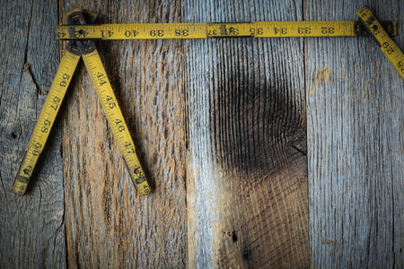 Old Tape Measure for Construction on Rustic Wood Backgroundの写真素材