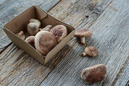 Shitake Mushroom in Cardboard Packaging on Wood Backgroundの写真素材