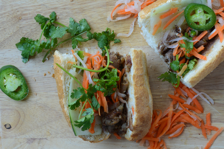 Vietnamese Grilled Pork Banh Mi Sandwich on Rustic Wood Backgroundの写真素材