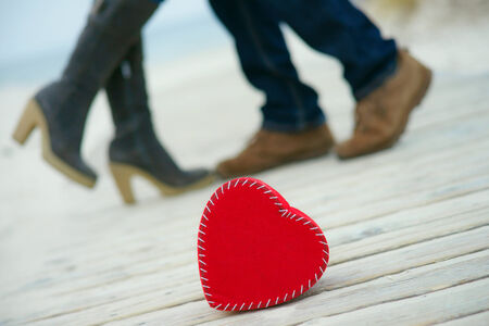 Red heart on the road with man`s and woman`s feetの写真素材