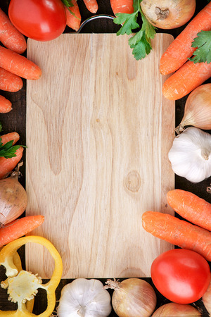 Fresh vegetables mix around wooden cutting boardの写真素材