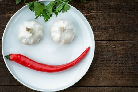 Smiley face made from pepper, garlic and parsleyの写真素材