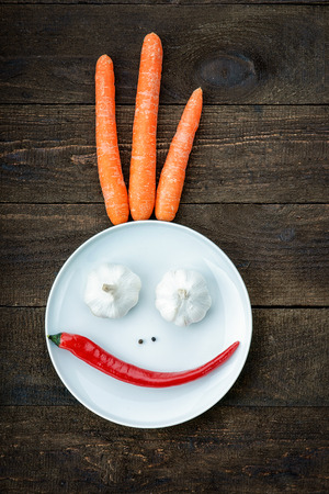 Smiley face made from pepper, garlic,flavoring and carrotsの写真素材