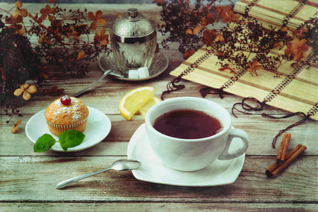 Cup of black tea and muffin with texture effectの写真素材