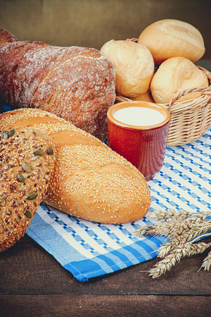 Cup of milk with assortment of baked breadの写真素材