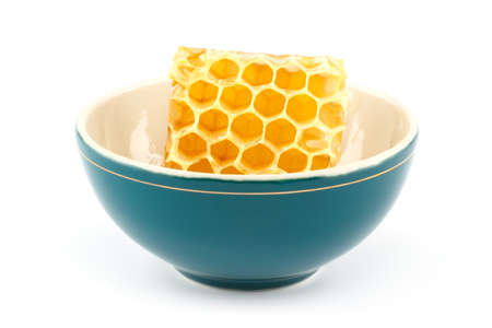 Honeycomb in green porcelain bowl on white isolated backgroundの写真素材