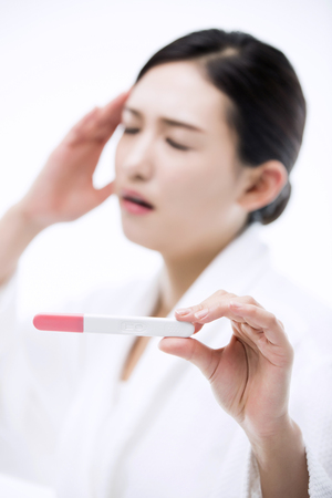 Asian Woman with Pregnancy Testの写真素材