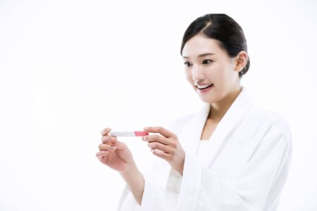 Asian Woman with Pregnancy Testの写真素材
