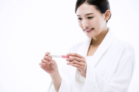Asian Woman with Pregnancy Testの写真素材