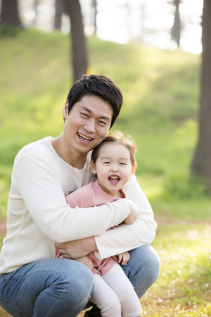Happy Asian Father and Daughter Smiling and Posing in Forest