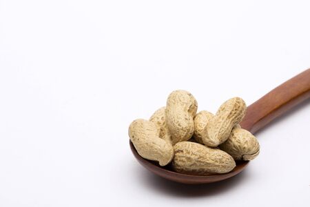 Peanut Shells on a Wooden Ladle, Isolated on Whiteの写真素材