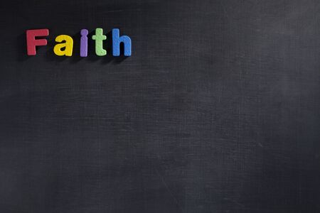 Magnetic letters on blackboard spelling out Faithの写真素材