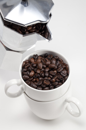 Coffee beans being poured into a coffee cupの写真素材