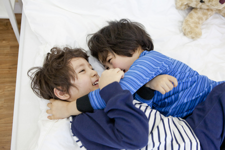 A child in bed with a friendの写真素材