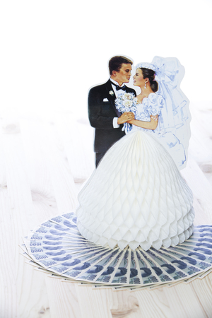 A miniature married model couple with money for a houseの写真素材