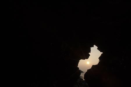 Bright sunglight fall into the dark caveの写真素材