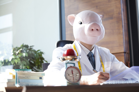 Dietitian wearing a pig maskの写真素材
