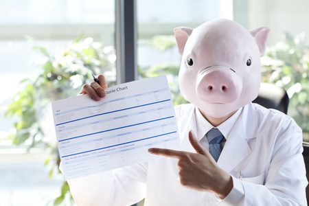 Dietitian wearing a pig maskの写真素材