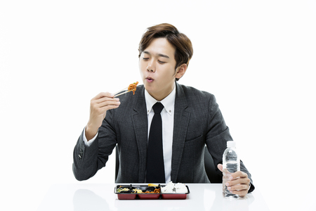 Young Businessman Eating From A Lunch Boxの写真素材