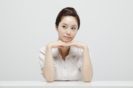Young Businesswoman With Jacket Off Sitting At A Deskの写真素材
