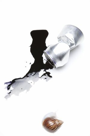 A Snail And A Crumpled Can With Black Ink Flowing Out Of Itの写真素材