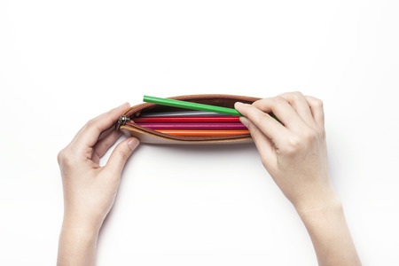 A leather pencil case with two hands - isolated on whiteの写真素材