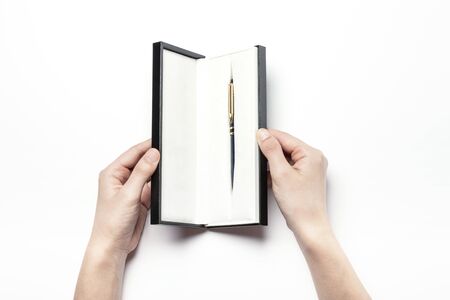 Close up shot of two hands opening a fountain pen case-isolated on whiteの写真素材