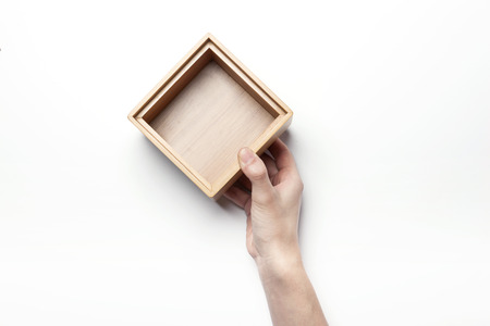 Close up shot of hands holding a wooden box/container-isolated on whiteの写真素材